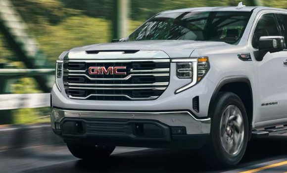 close-up_view_of_front_end_of_the_GMC_sierra_driving_down_road.jpg
